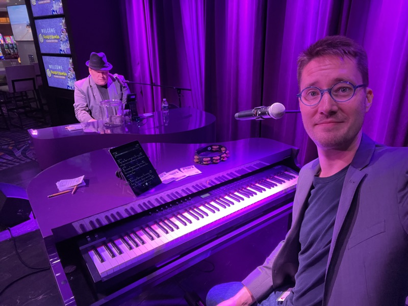 Both performers at keyboards under purple stage lighting